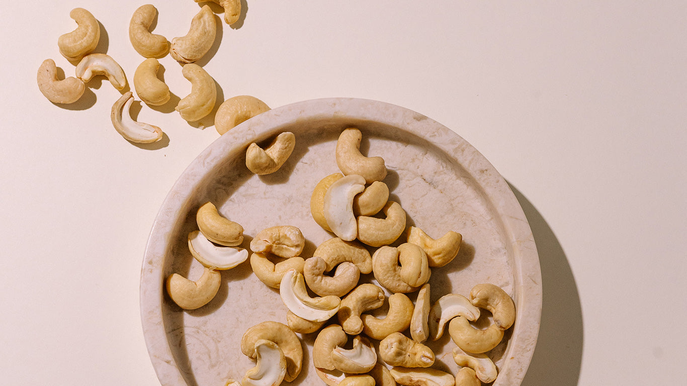 Cashew nuts on a stone plate with a light background