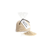 Bag of white sesame seeds with a visible brand label on a white background